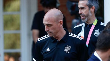 Luis Rubiales, wearing a soccer jersey, walks down some steps at an event.