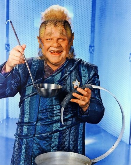 A promotional image for Star Trek: Voyager featuring Neetlix holding a soup ladle and a serving apparatus piped out of a cooking pot.