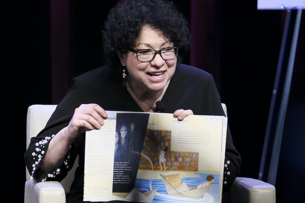 Supreme Court Justice Sonia Sotomayor reads from a children's book, showing the pictures.