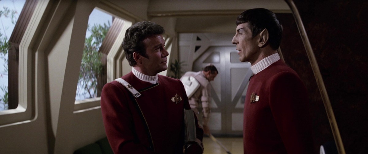 A screen capture of Star Trek: Wrath of Khan that shows a janitor cleaning behind Kirk and Spock.