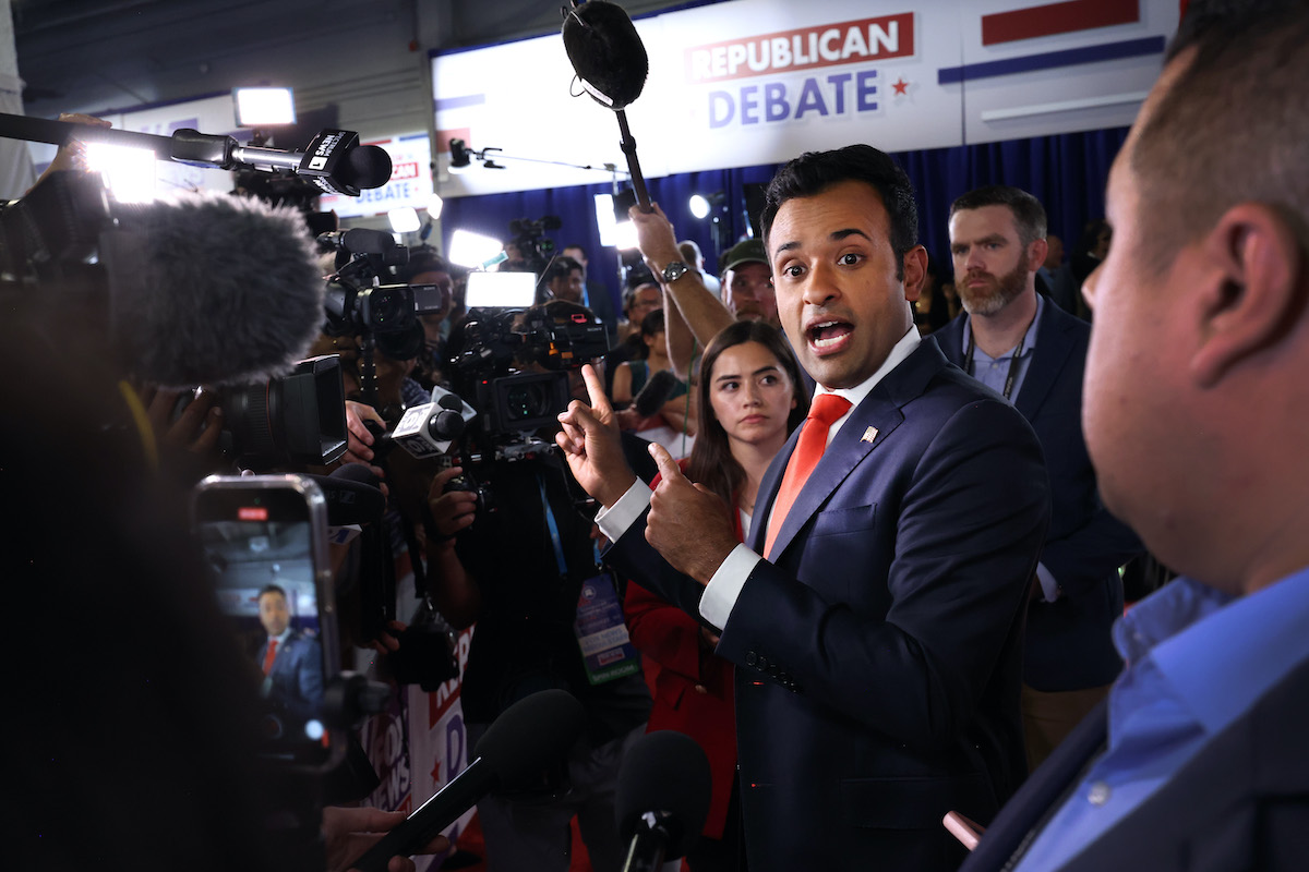 Vivek Ramaswamy speaks animatedly to reporters.