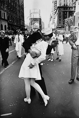 A sailor and dental assistant dressed in a white uniform kiss in Times Square.