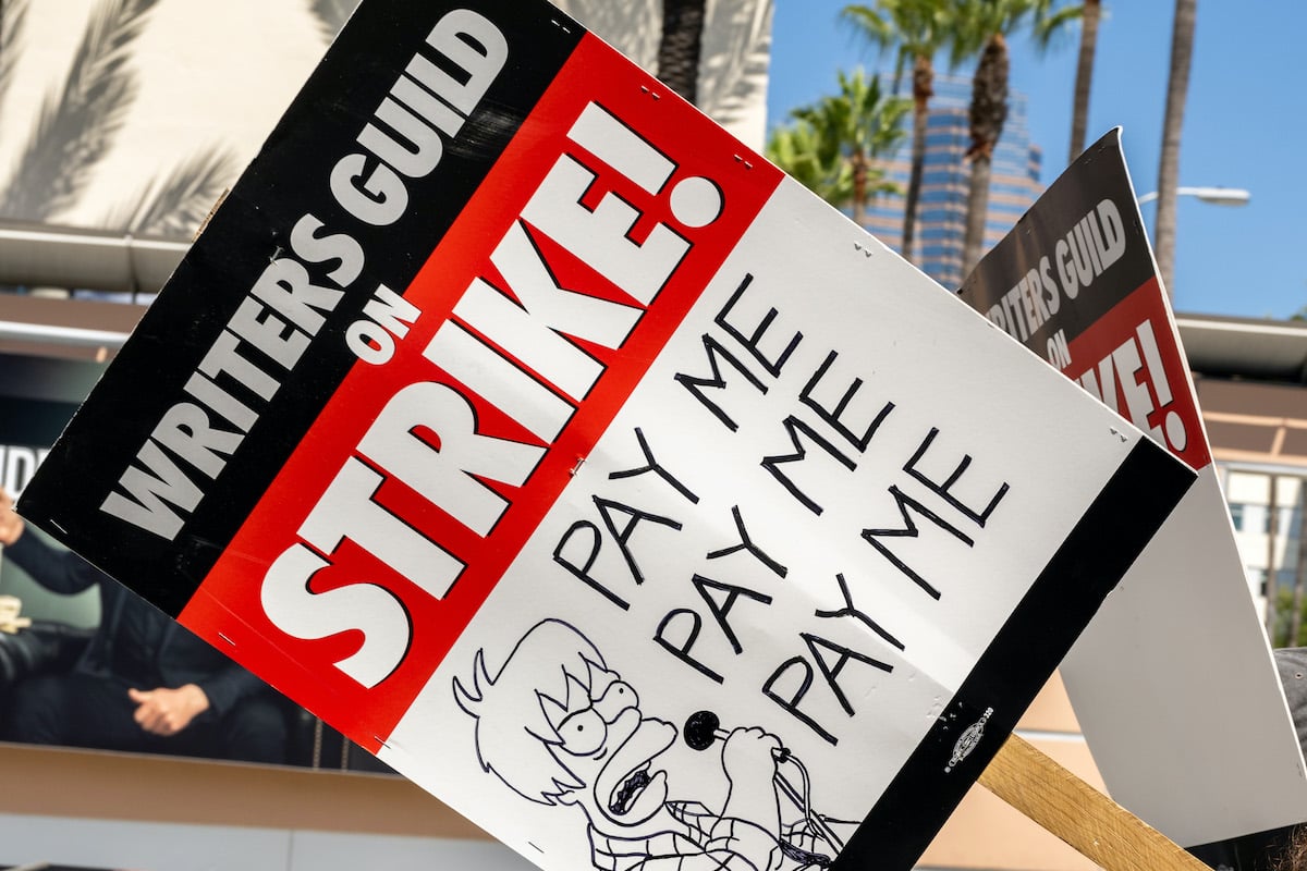 A WGA strike picket sign featuring a Simpsons-style drawing reading "Pay me"