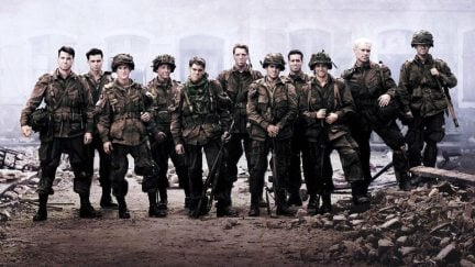 Eleven soldiers dressed in WWII fatigues stand in a city turned to rubble in 'Band of Brothers'