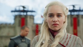 Daenerys, a white-haired woman looks disgusted with a castle wall behind her in 'Game of Thrones.'