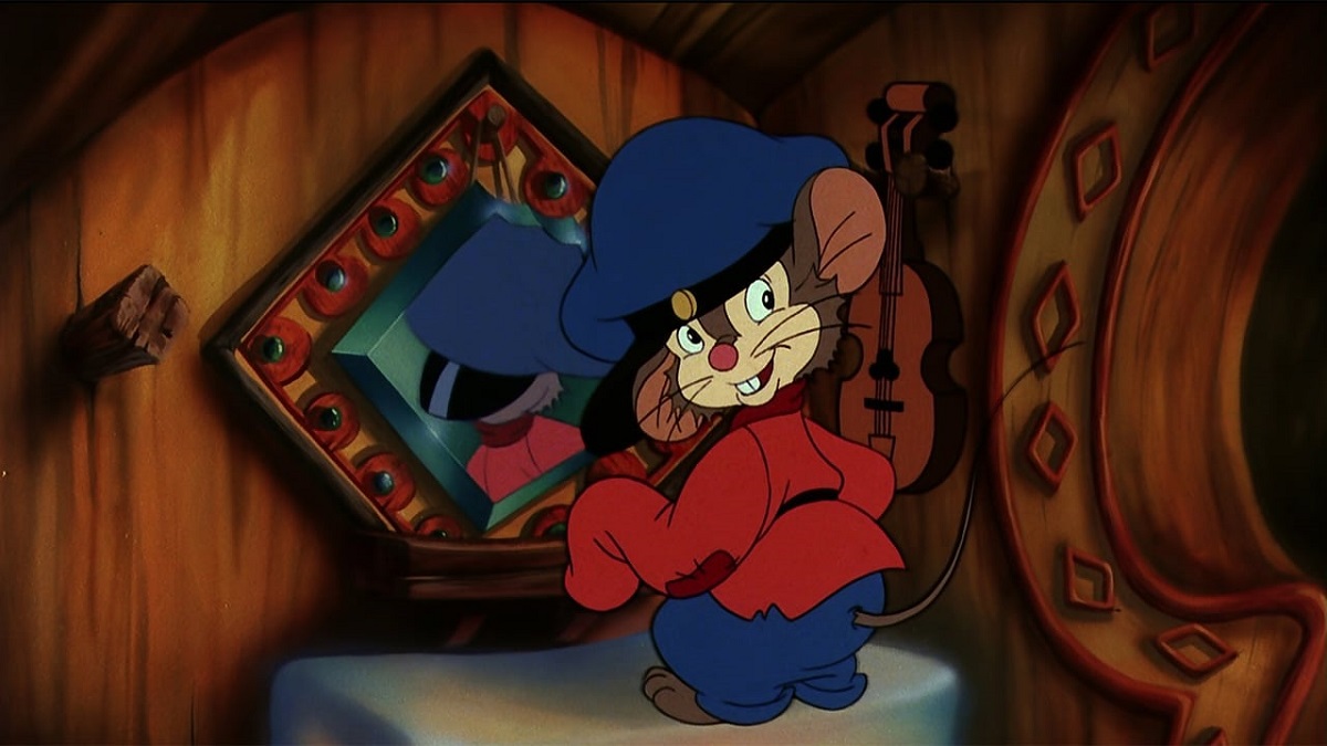 Fievel the mouse from the animated film 'An American Tail.' He is a brown mouse standing in front of a little mirror wearing an oversized red shirt, blue pants, and a blue hat. He's looking over his shoulder.