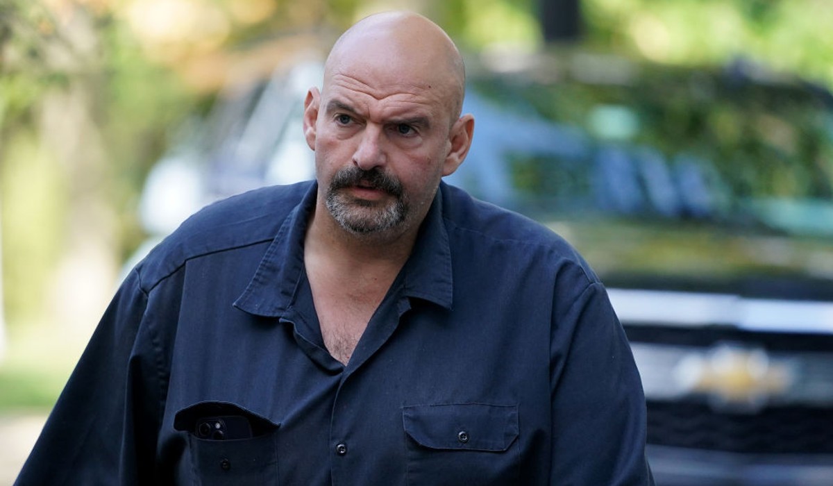 John Fetterman, Senator from PA, wears a collard shirt while walking. 