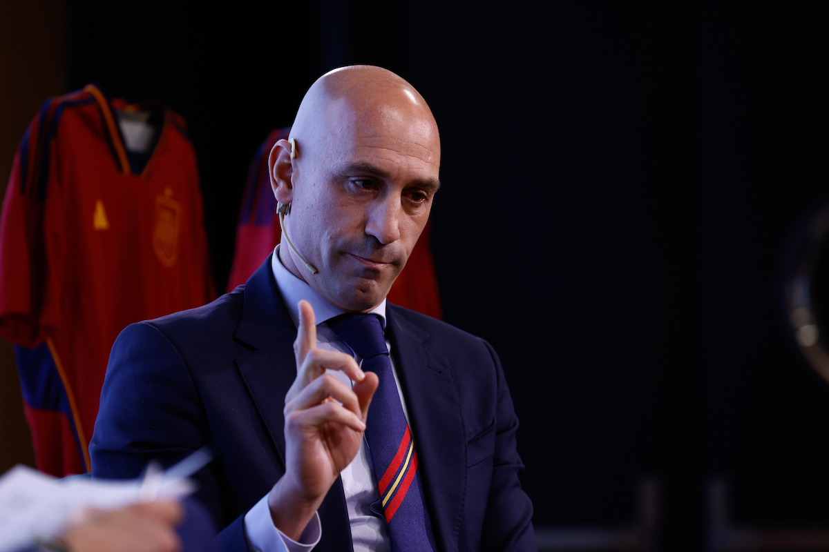Luis Rubiales speaks and holds one finger up.