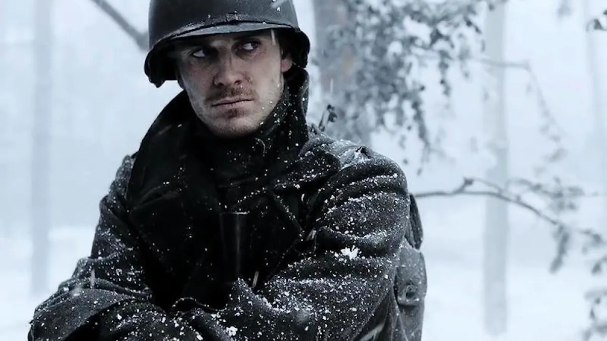 A solider stand huddled in the snow in 'Band of Brothers.'