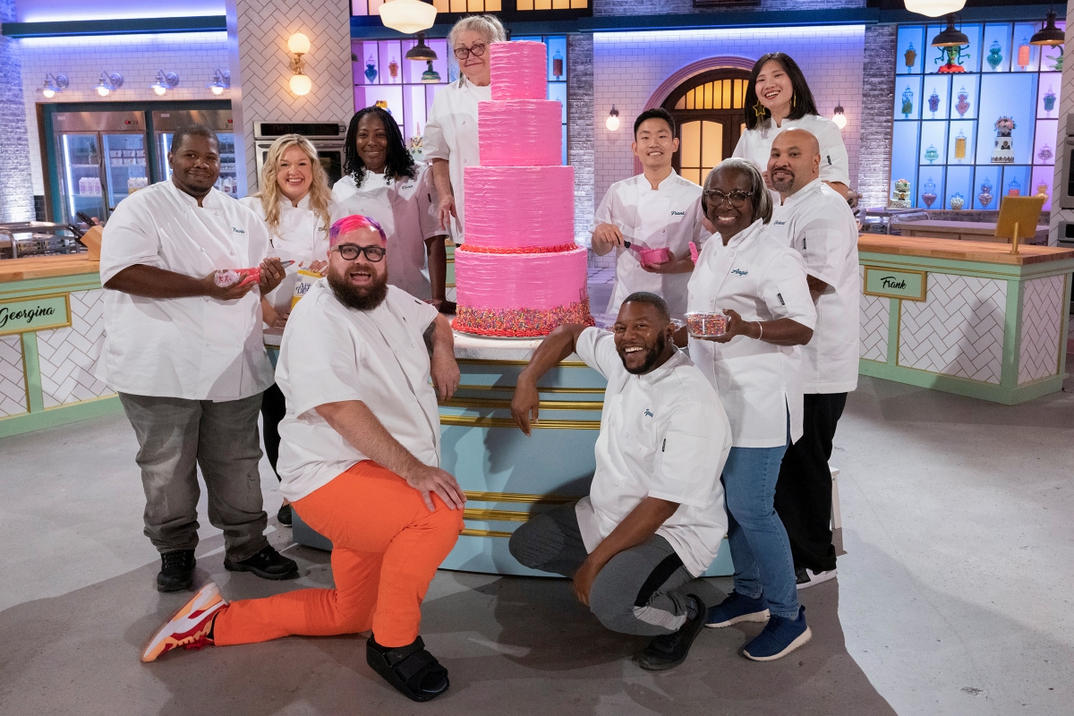 Travis Smith, Emily Adey, Andy Bisaha, Cura Johnson, Jean Silber, Ignoisco Miles, Frank Hu, Angie Williams, Georgina Chiou, and Richard Sanchez pose around a tiered cake in The Big Nailed It! Baking Challenge Season 1
