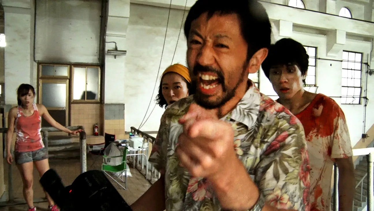 Film director Takayuki Higurashi (Takayuki Hamatsu) shouts instructions at the camera in front of his theatrical blood-covered crew in ‘One Cut of the Dead.’ 