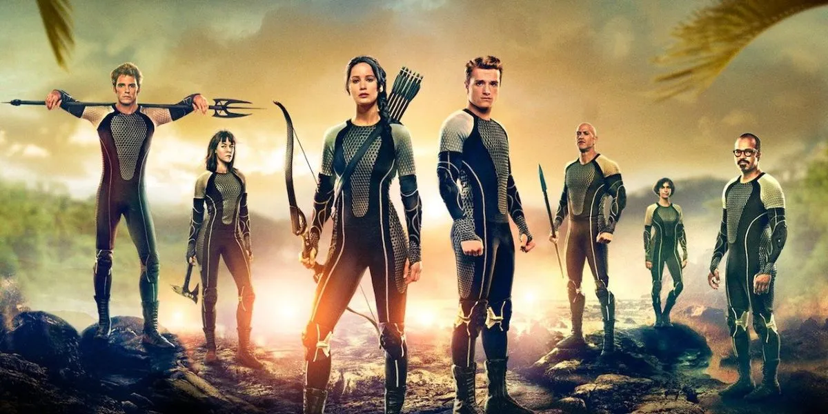 A group of seven people wear uniforms and hold various weapons in 'The Hunger Games: Catching Fire.'