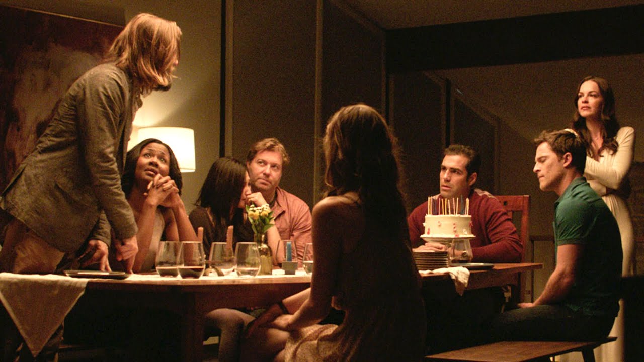 A group of people have a heated discussion around a table in 'The Invitation'
