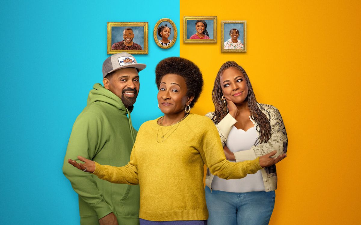 Three Black adults pose for the camera as four framed photos of their children are behind them in the sitcom 'The Upshaws'