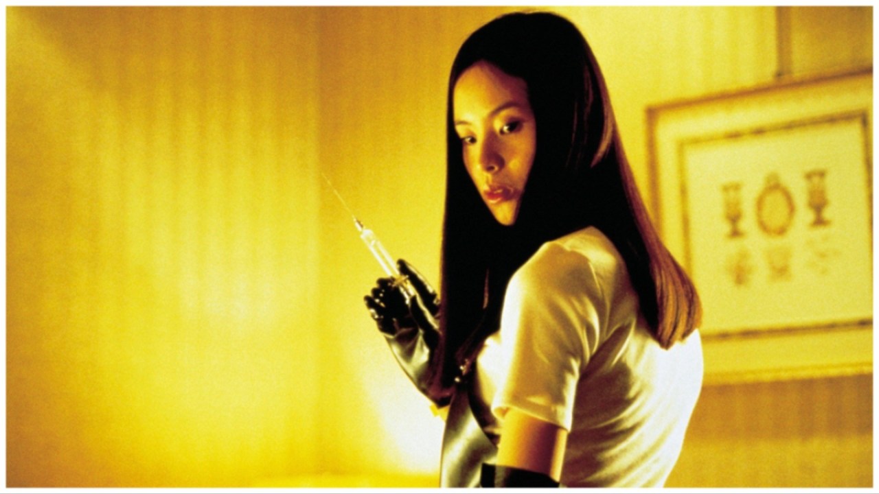 Asami (Eihi Shiina) stands in a hotel room holding a long syringe in Takashi Miike's "Audition".