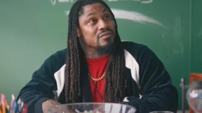 Marshawn Lynch sits at a teacher's desk in a scene from Bottoms.