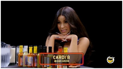 Cardi B sits at the table ready to eat wings on 'Hot Ones'.