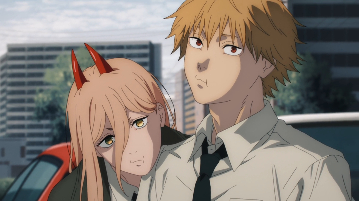 A young man and woman stand in a cityscape leaning on each other while staring that the camera in "Chainsaw Man"