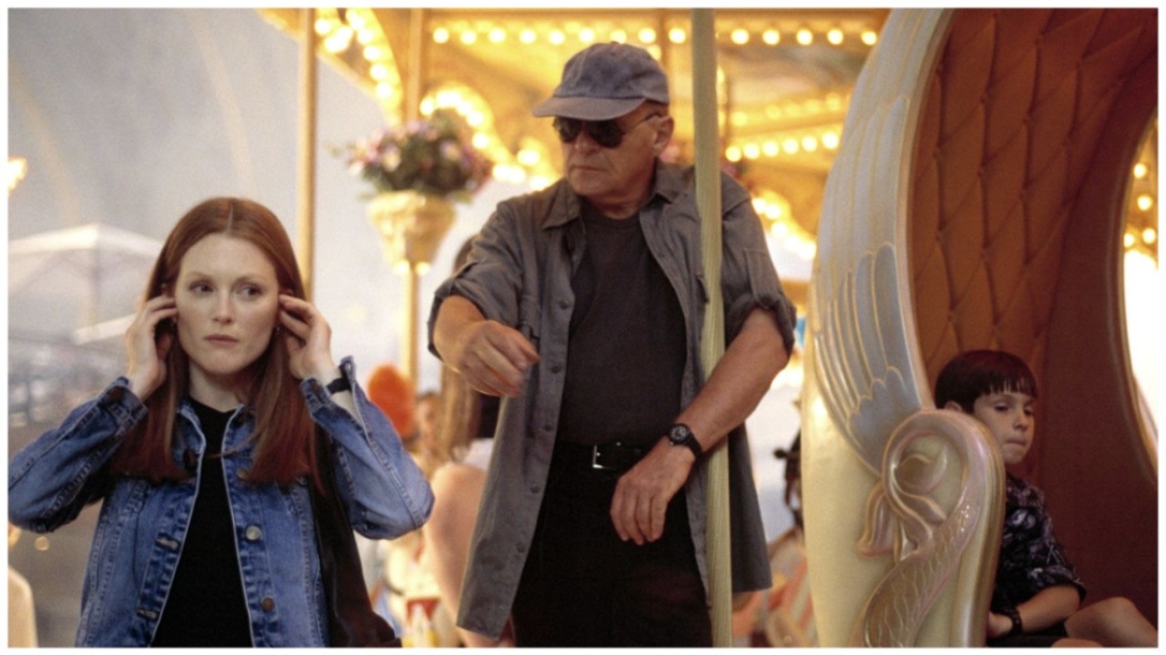 Julianne Moore and Anthony Hopkins in 'Hannibal'. Julianne listens to headphones as Anthony stands behind her on a carousel.
