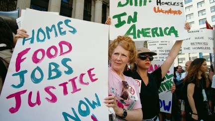 Women hold signs during a homeless and hunger demonstration outside the Federal Courthouse on Wall Street. Demonstrators protested and called for better treatment of the homeless during the 1993 Democratic National Convention. | Location: Financial District, Lower Manhattan, New York, USA.