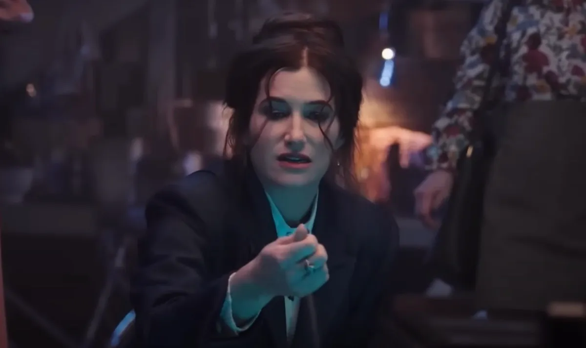 Kathryn Hahn as Agatha Harkness, examining something in her hand.