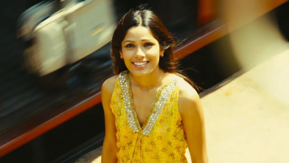 The young woman Latika standing in a train station looking up and smiling in "Slumdog Millionaire"
