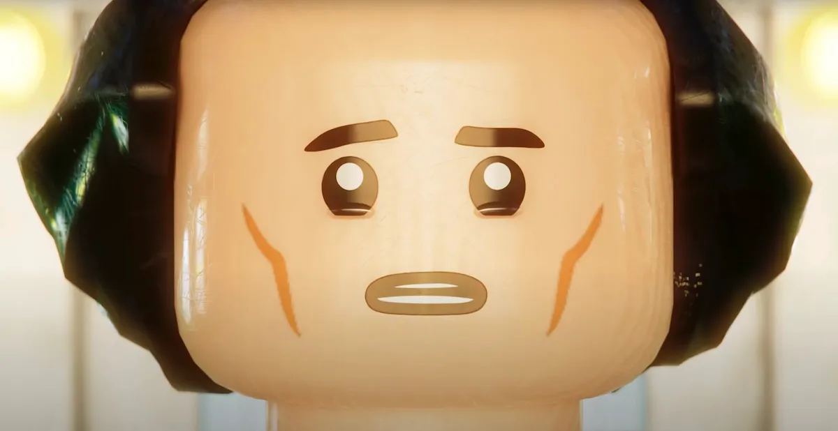 Close up of Loki's face in LEGO form. LEGO Loki looks at a bright light in front of him, worried.