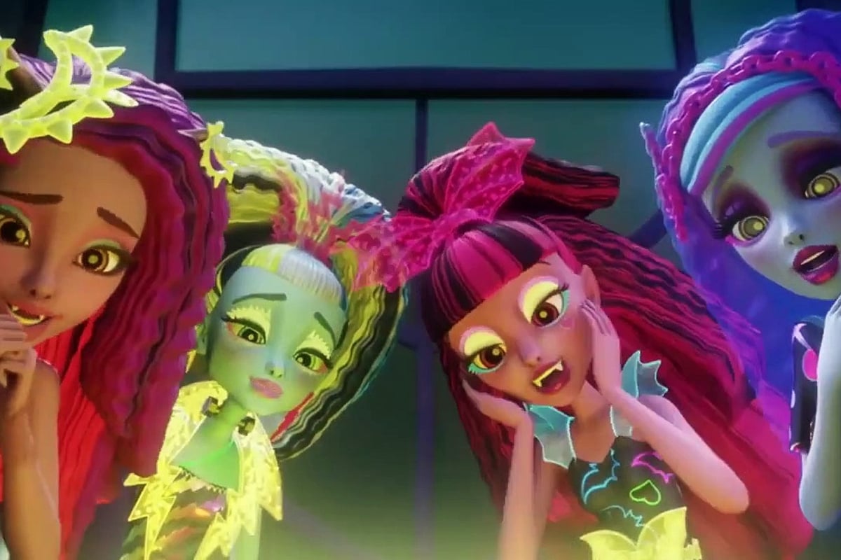 Monster High: Electrified; Clawdeen, Laguna, Draculaura, and Ghoulia stand around something below the level of the screen, looking down at it. Their hair is crimped, they were neon makeup, and their dresses are glowing.