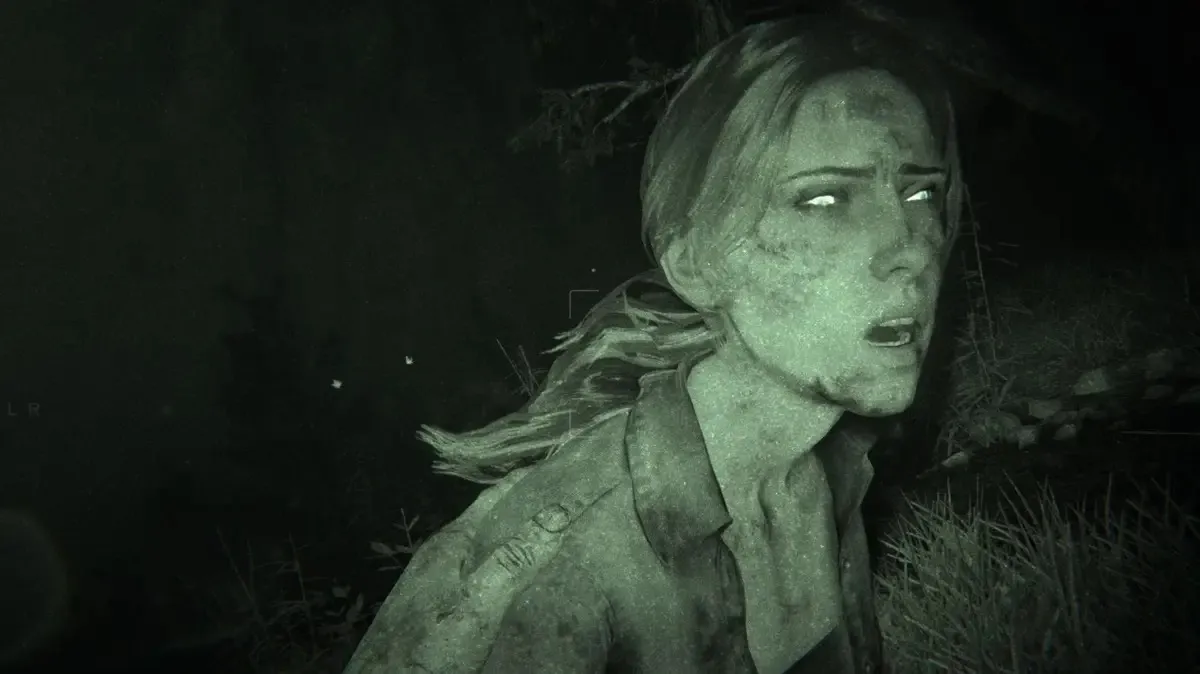 An exhausted woman stands in the woods illuminated by a night vision camera in "Outlast II"