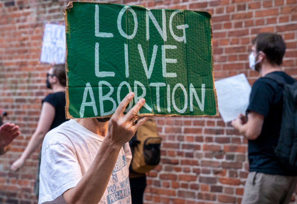 A protester holds a sign that says "Long Live Abortion."