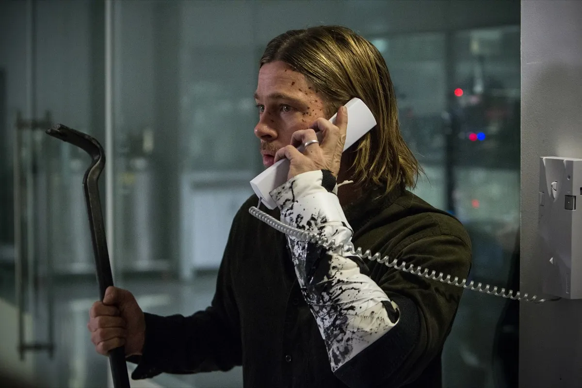 Brad Pitt holds a phone and a crowbar in 'World War Z'.