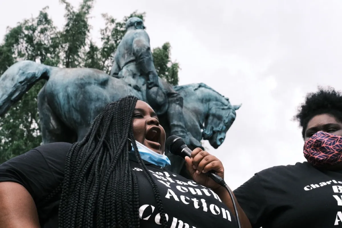 Zyahna Bryant speaks into a microphone outdoors at a protest.
