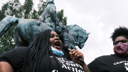 Zyahna Bryant speaks into a microphone outdoors at a protest.