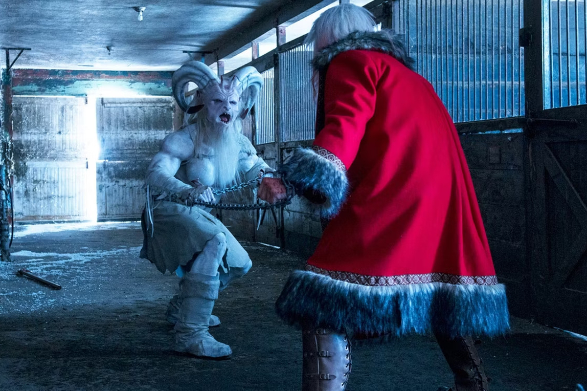 Still from a Christmas horror story; Santa faces off against Krampus, a white painted, horned demon figure.