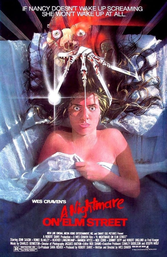 A girl stares up in her bed as bladed hands hang over her face in "A Nightmare On Elm Street"