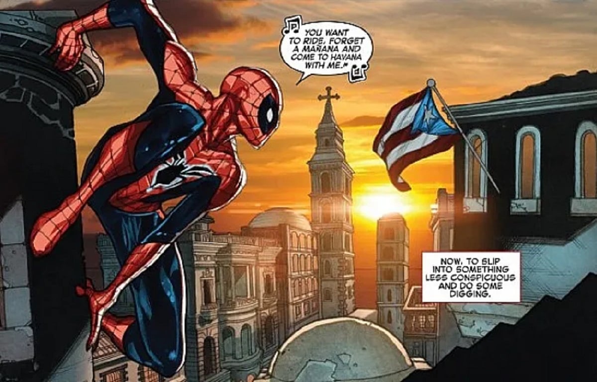Image from a panel of issue #1.2 of 2016's "The Amazing Spider-Man." Spider-Man is perched on a building overlooking what is supposed to be a city in Cuba, but across the way from him a Puerto Rican flag is flying. 