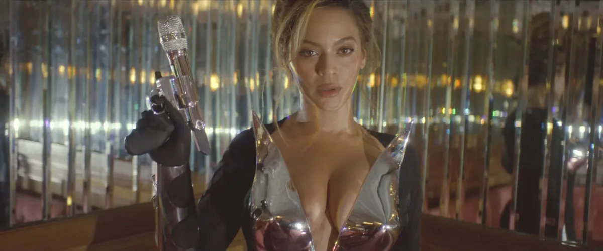 Beyoncé teasing her song 'I'm That Girl' from 'Renaissance' with a microphone gun and chrome fit.