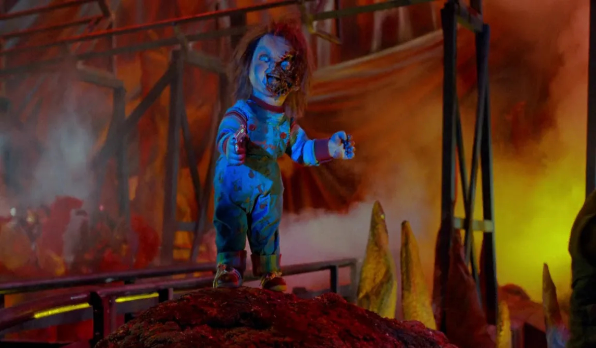 A partially burnt Chucky doll stands in the flames in 'Child's Play 3'.
