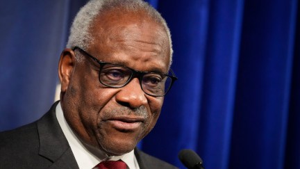 Clarence Thomas head and shoulders in 2021 in front of blue curtain