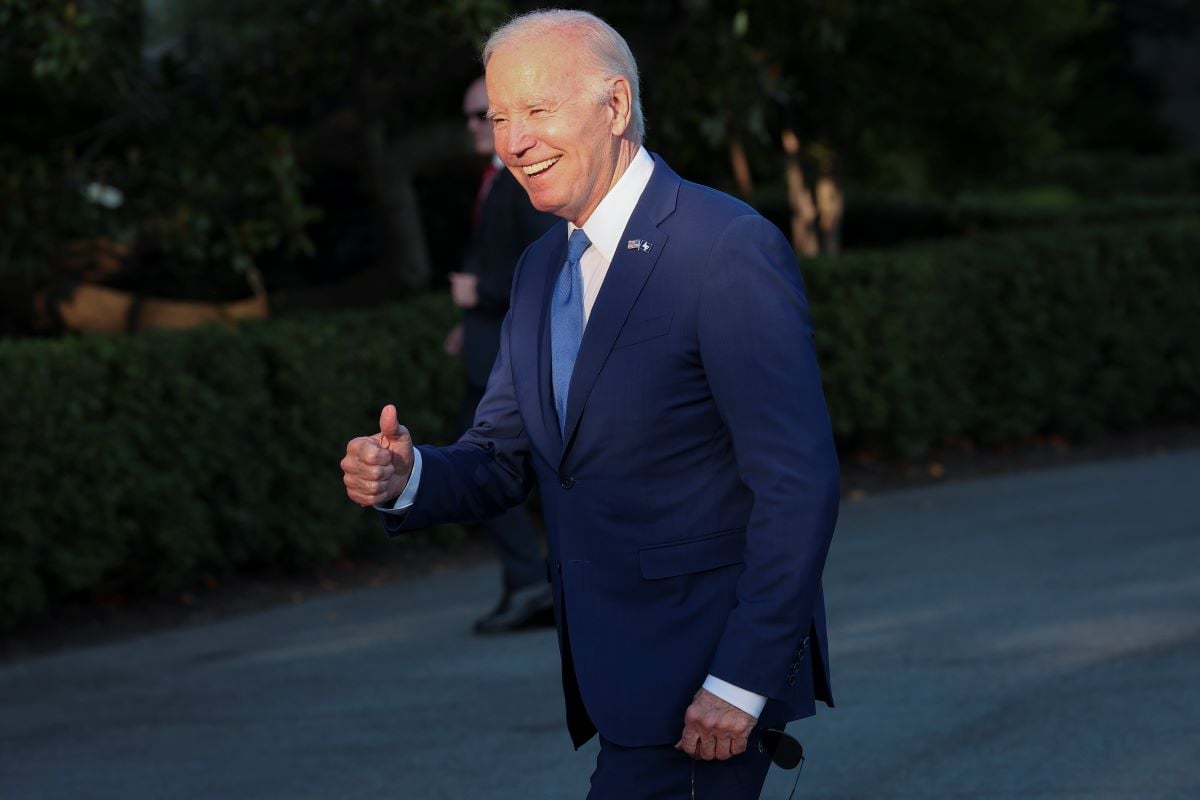 A smiling Joe Biden jokes with reporters while returning to the White House in June 2023.