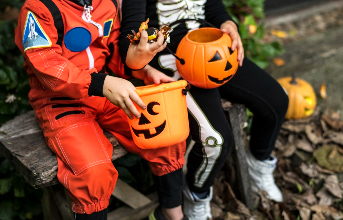 Kids in costumes with buckets of candy on Halloween
