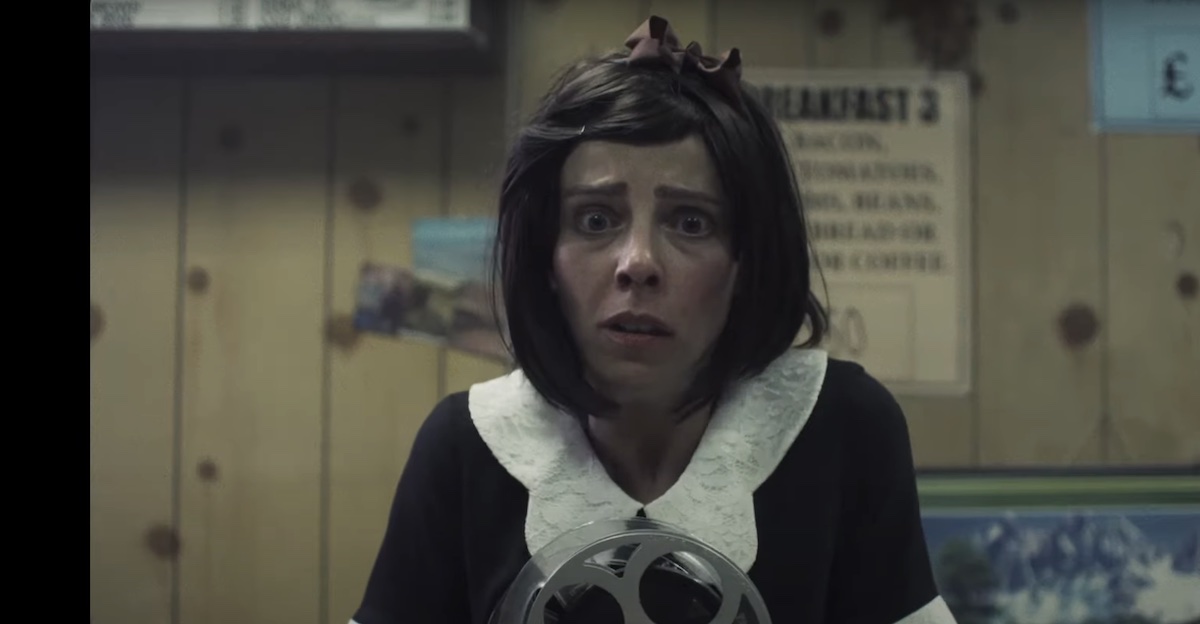 Nora (Sophia Di Martino) clutches a film reel, looking pained.