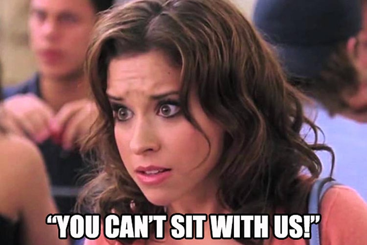 Dark haired woman leans forward with text "You can't sit with us" in 'Mean Girls.'