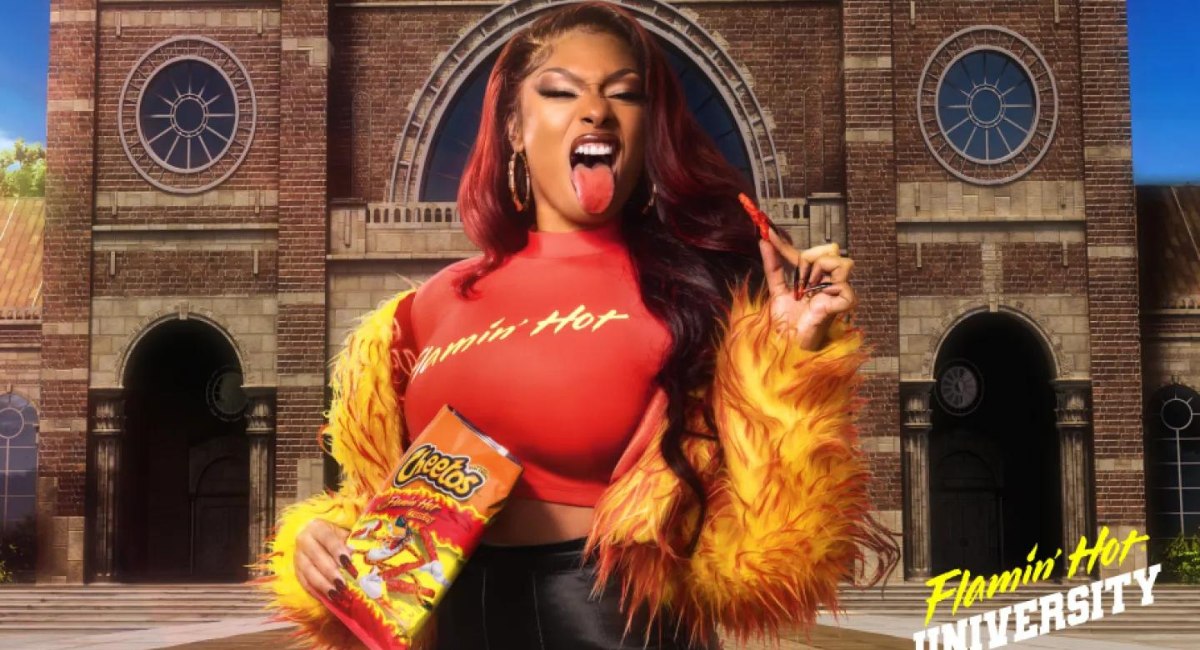 Meg Thee Stallion holding a bag of Flamin' Hot Cheetos