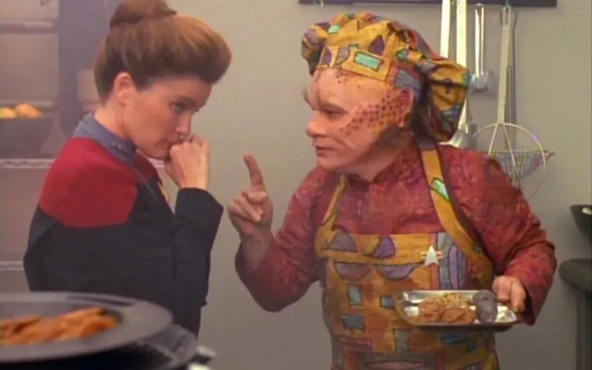 Neelix (Ethan Phillips) feeds Captain Janeway (Kate Mulgrew)