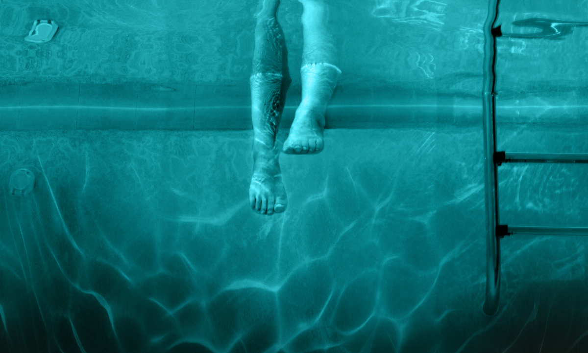Feet dangle ominously in a swimming pool in the poster for 'Night Swim'