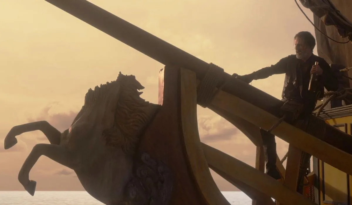 Izzy Hands, played by Con O'Neill, stands at the bow of the Revenge looking over the unicorn figurehead in the second season of Our Flag Means Death