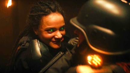 A woman with glowing eyes attacks a man wearing a helmet in 'Loki'.