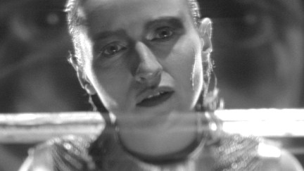 A warrior woman holds a sword over her shoulders in 'SHE IS CONANN.'