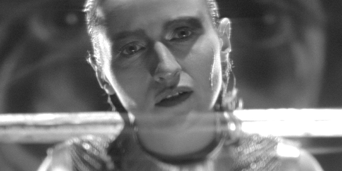 A warrior woman holds a sword over her shoulders in 'SHE IS CONANN.'